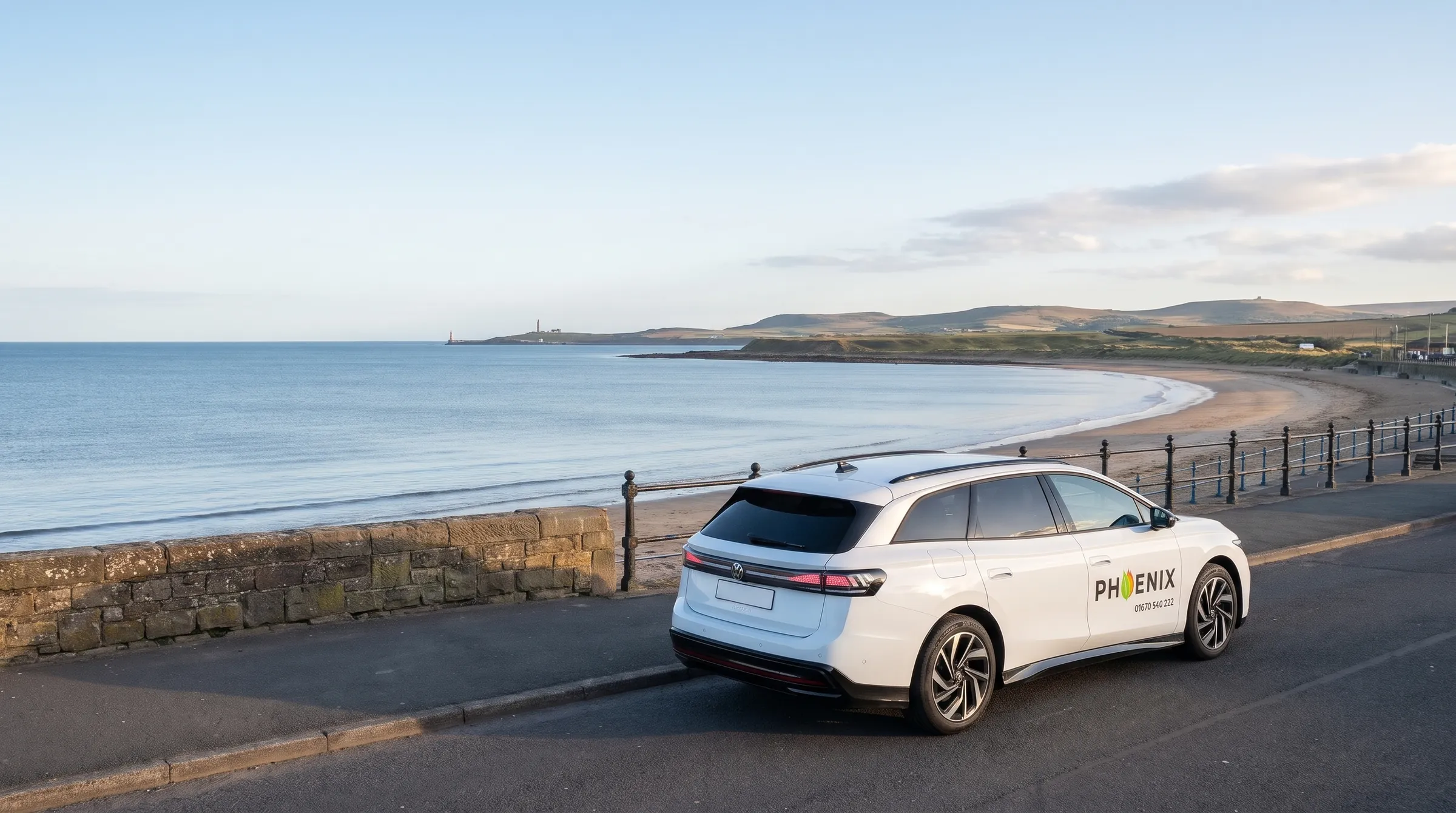 A Phoenix Volkswagen ID.7 on a seafront road above a sandy bay